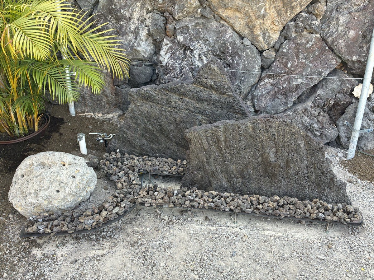 KAZ custom fire strips and bowl installation against lava rock wall